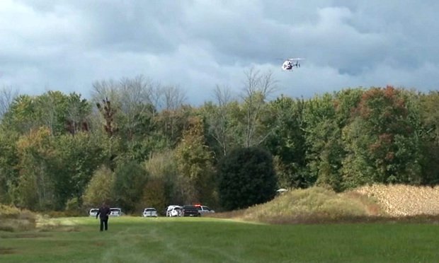 In this photo from Spectrum News Buffalo, a helicopter orbits the site of a small plane crash near Pembroke, New York on October 2, 2020.  Two people on board the plane died.  (Spectrum News Buffalo via AP)