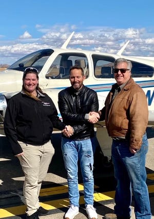 Local attorney Samuel Kane recently obtained his commercial pilot license.  He is pictured here with flight instructor Sarah Rovner and the Federal Aviation Administration examiner.